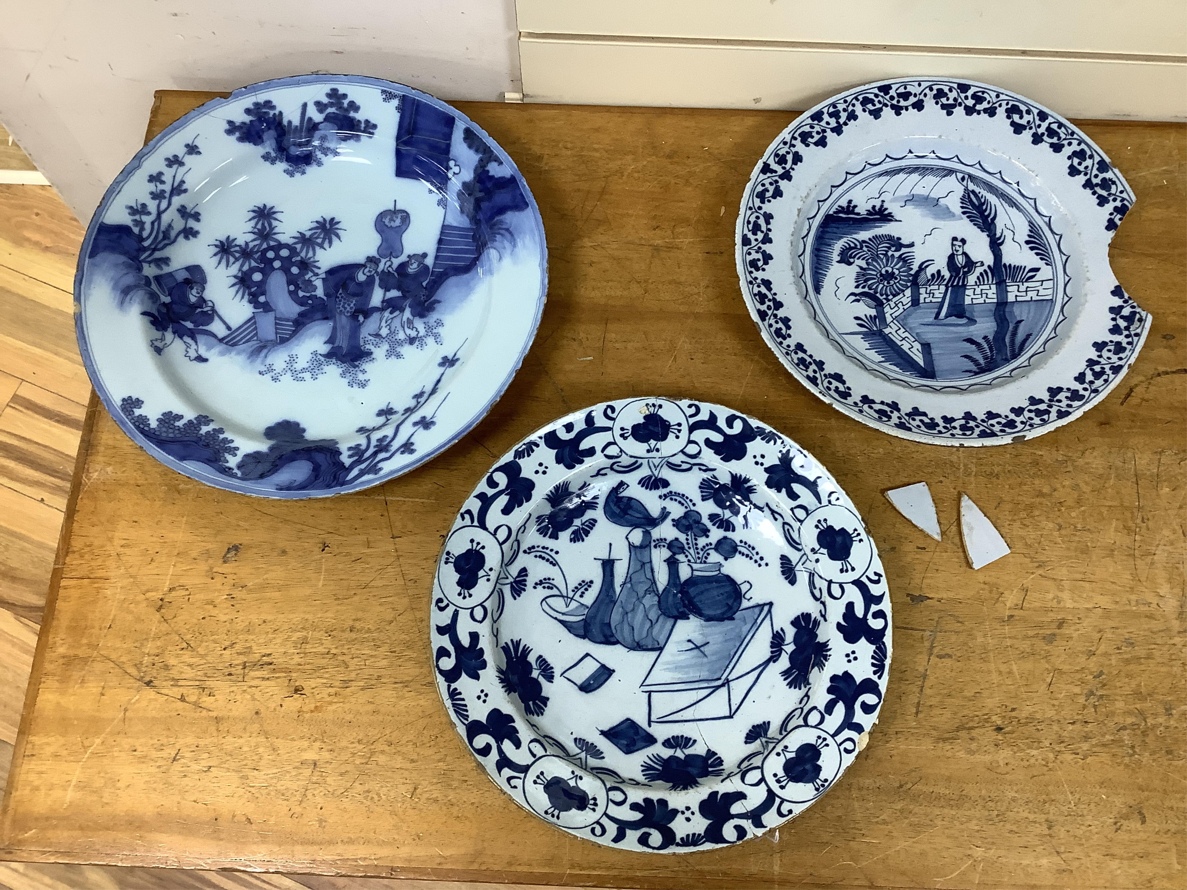 An 18th century English delftware ‘Chinese figures’ dish and two similar Delft dishes, largest 39cm diameter (3), largest 39cm
